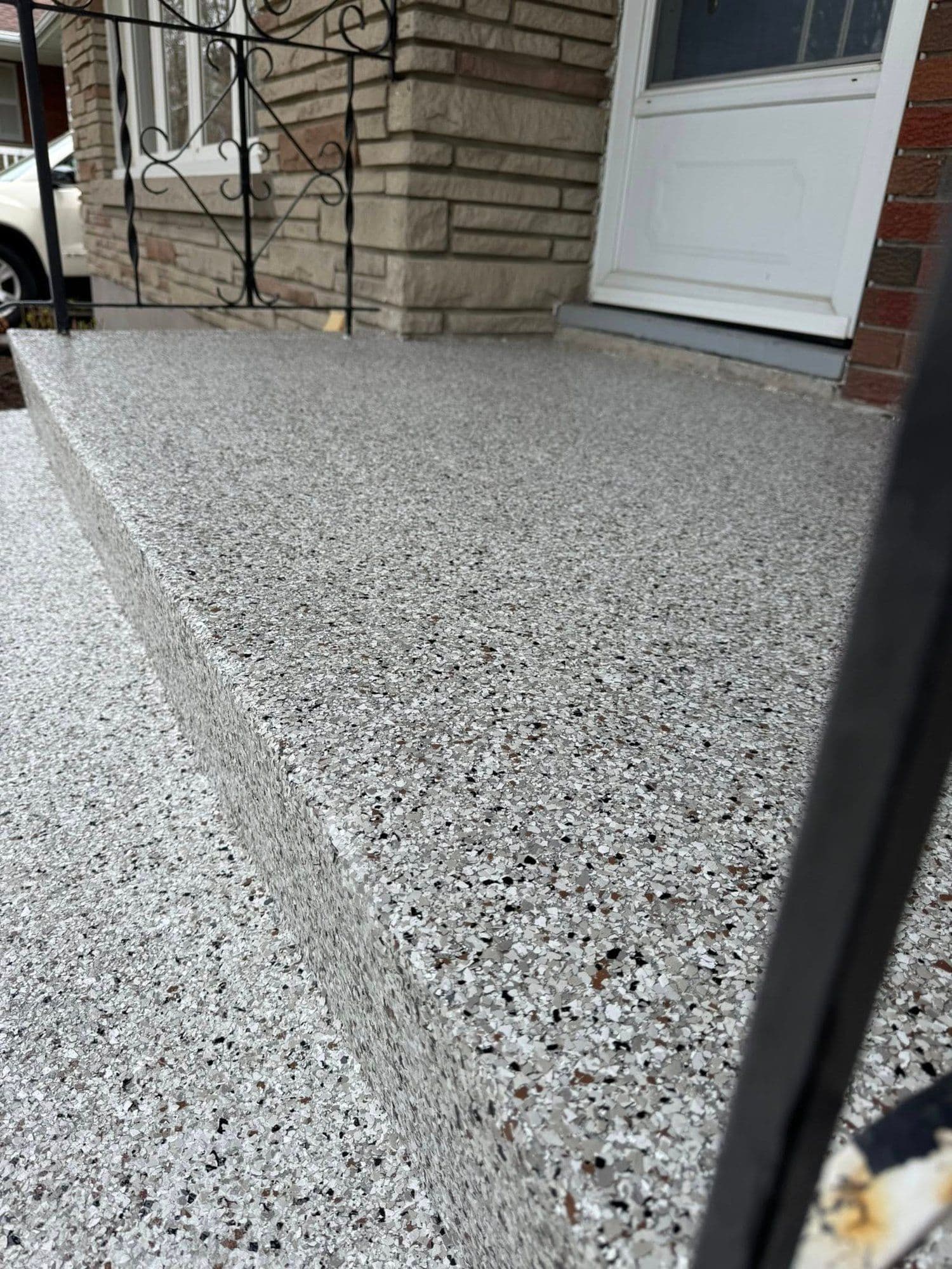 Close-up of a grey flake epoxy floor edge and high-gloss finish