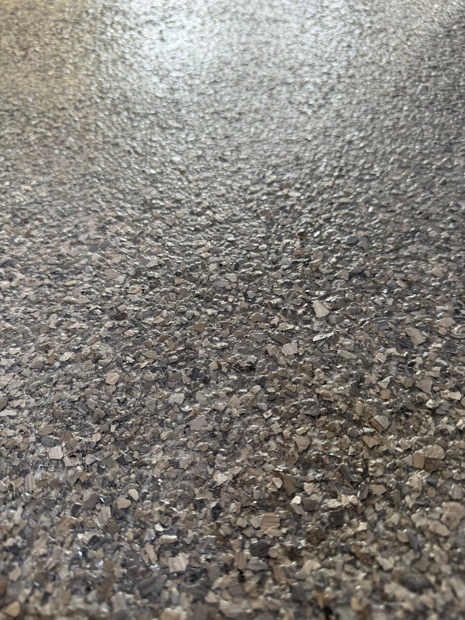 Close-up of a warm tan and grey flake epoxy coating
